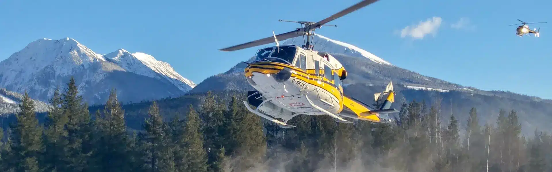 Photo of Bell 212 FKJX about to land at heli-skiing lodge